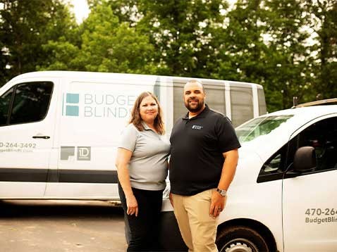 The business owners standing side by side, in front of the company vehicle